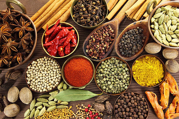 A vibrant collection of nutrient-dense organic superfoods and raw medicinal spices in small wooden bowls
