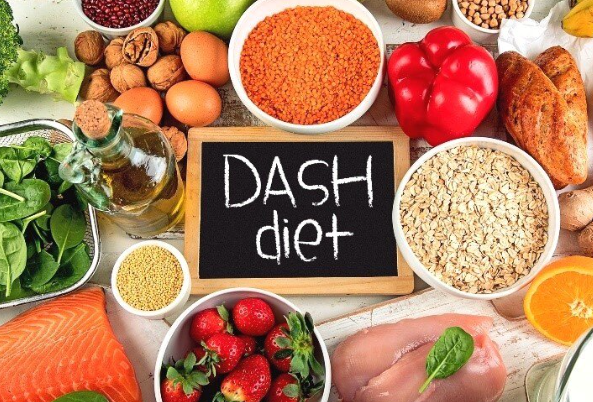 A healthy DASH diet food spread containing low-sodium grains, potassium-rich leafy vegetables, organic fruits, and low-fat dairy staples.