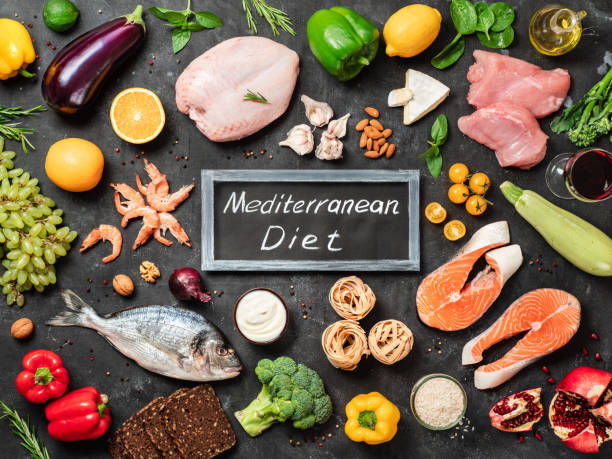 A classic Mediterranean food arrangement featuring cold-pressed extra virgin olive oil, wild salmon, fresh tomatoes, garlic, olives, and whole grains.