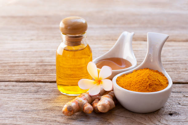 Fresh orange turmeric rhizomes and ground yellow turmeric powder with black pepper corns, highlighting curcumin NF-kB anti-inflammation.
