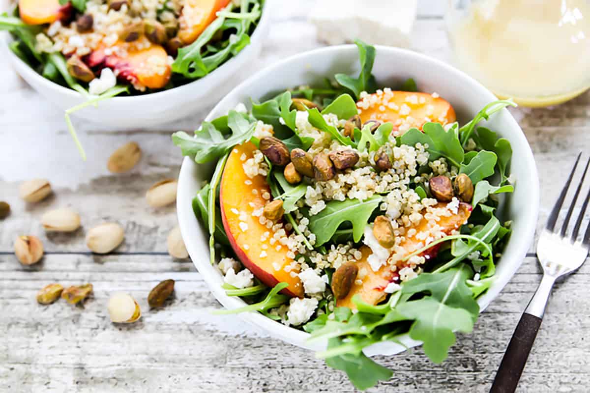 A colorful quinoa salad with diced cucumbers, cherry tomatoes, parsley, and olive oil vinaigrette.