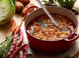 A steaming bowl of traditional Sardinian Minestrone rich in fava beans, chickpeas, white beans, and garden vegetables.